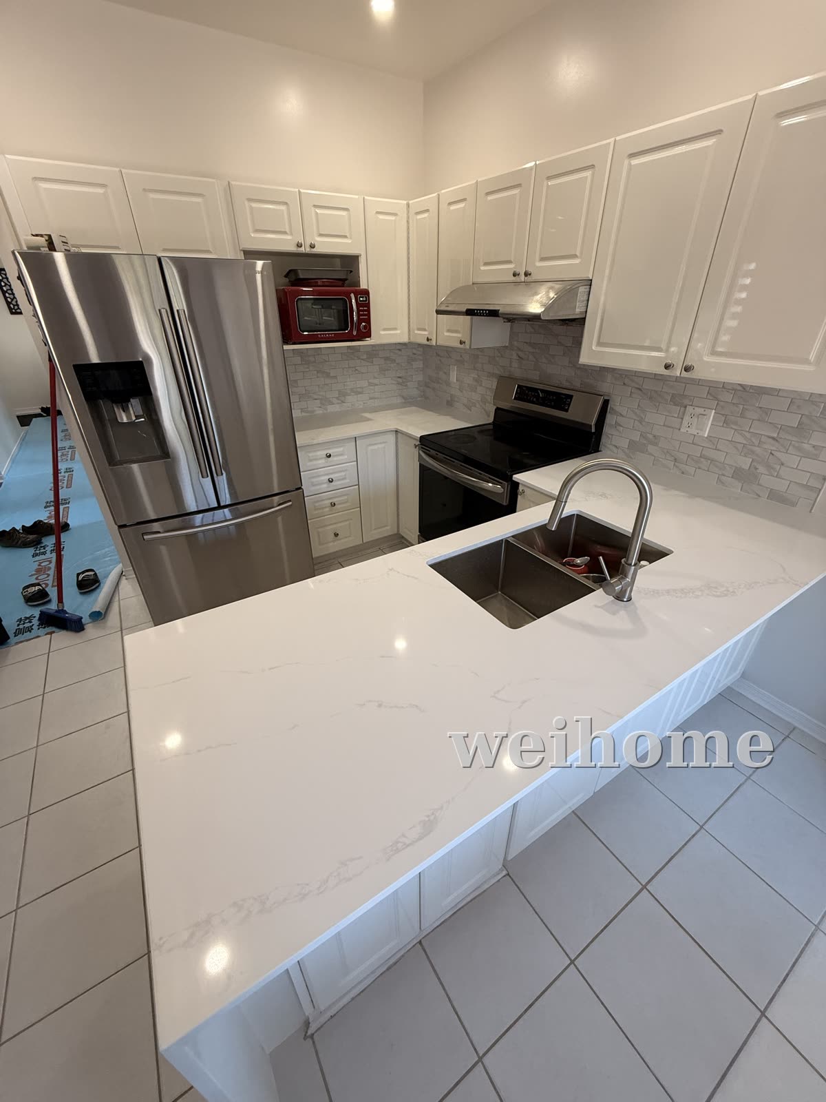 Kitchen after — white quartz waterfall countertop & backsplash