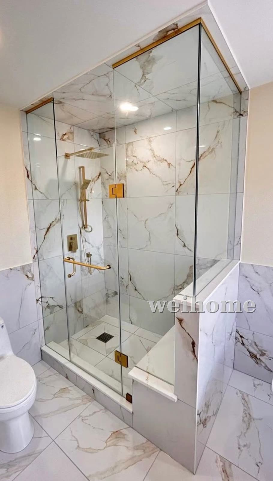 Frameless glass shower with brushed gold hardware